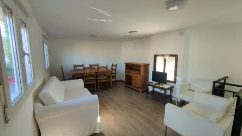 a living room with two white chairs and a television at House Casa in Sotillo de la Adrada in Sotillo de la Adrada