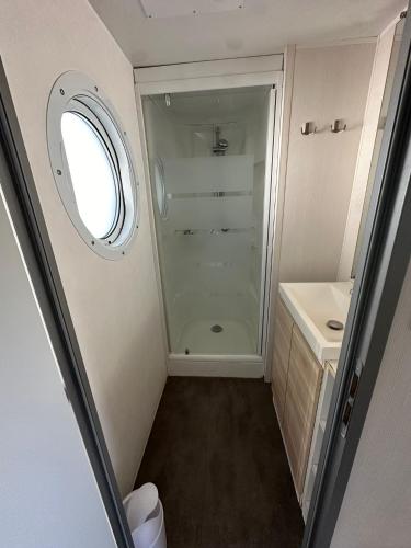 La petite salle de bains est pourvue d'une douche et d'un lavabo. dans l'établissement Camping domaine Saint Martin 4 étoiles, à Casteil