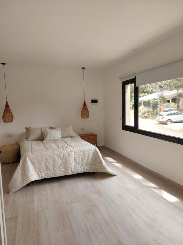 a bedroom with a bed and a large window at Senderos del Mar in Monte Hermoso