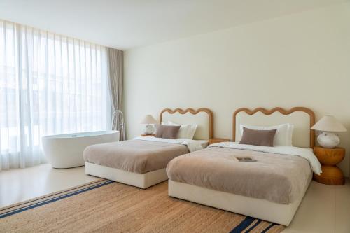 a bedroom with two beds and a bath tub at 礼橖LoveTime·美学海景民宿（较场尾大鹏所城店） in Shenzhen