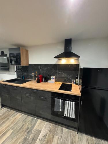 a kitchen with a stove and a black refrigerator at L'écrin in Bourges