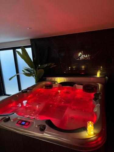 a hot tub with red liquid in a room with a window at L'écrin in Bourges