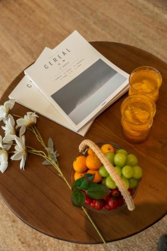 a book and a bowl of fruit on a table at 礼橖LoveTime·美学海景民宿（较场尾大鹏所城店） in Shenzhen
