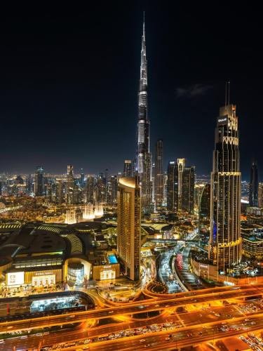 a city skyline at night with a busy freeway at Royal Vista - Luxury 4BR Apartment at Downtown Views II - Downtown in Dubai