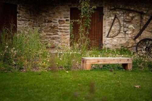 a wooden bench sitting in the grass in front of a building at Farma Kalhov in Kalhov