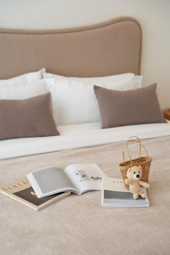 a bed with books and a teddy bear sitting on top of it at 礼橖LoveTime·美学海景民宿（较场尾大鹏所城店） in Shenzhen