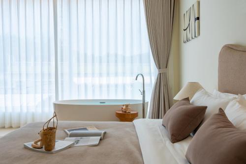 a bedroom with a bed with a tub in the window at 礼橖LoveTime·美学海景民宿（较场尾大鹏所城店） in Shenzhen