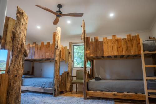 a bedroom with two bunk beds and a ceiling fan at Funday Farm Adelaide Hills in Norton Summit