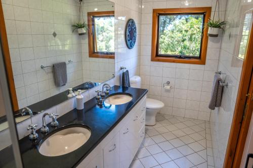a bathroom with two sinks and a toilet at Funday Farm Adelaide Hills in Norton Summit