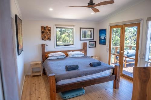 a bedroom with a bed with a ceiling fan at Funday Farm Adelaide Hills in Norton Summit