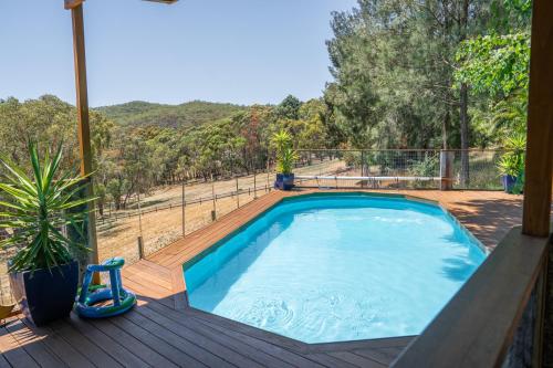 a pool on a deck with a view of a mountain at Funday Farm Adelaide Hills in Norton Summit