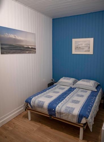 - une chambre avec des murs bleus et un lit avec des oreillers dans l'établissement Terrasse vue cathédrale et beffroi hyper centre, à Amiens