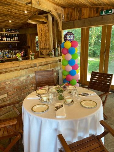 a table with a white table cloth and a balloon centerpiece at Burtree Country House, Tipi's, Treehouse & Lodge & house rooms with hot tubs in a private garden in Thirsk