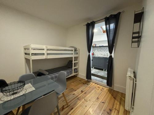 a small room with a desk and bunk beds at Confort 6 pers & Wi-Fi rapide in La Courneuve