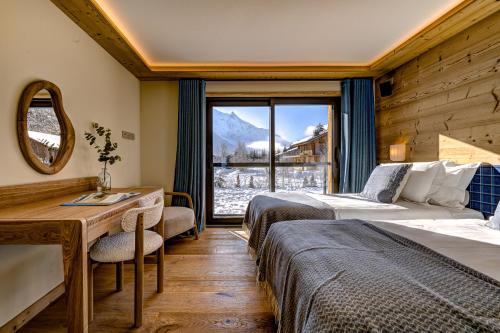 une chambre d'hôtel avec deux lits et une fenêtre dans l'établissement Chalet Josephine, Chamonix Les Bois, à Chamonix-Mont-Blanc