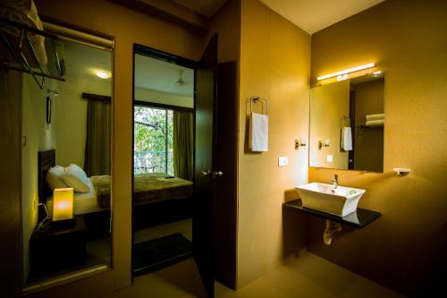 a bathroom with a sink and a mirror at Pinnacle Holiday Homes in Arpora