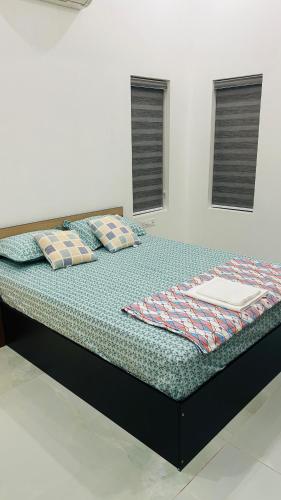 a large bed in a room with two windows at Grace Villa Homestay, Cherupuzha in Peringom