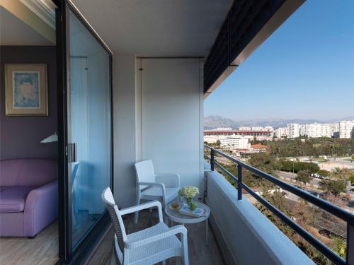 a balcony with a couch and chairs on a balcony at Rixos Downtown Antalya - The Land Of Legends Access in Antalya