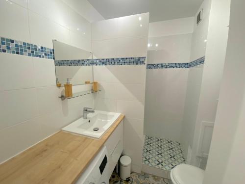 une salle de bain blanche avec un lavabo et un miroir dans l'établissement Studio avec piscine et jardin, à Sanary-sur-Mer