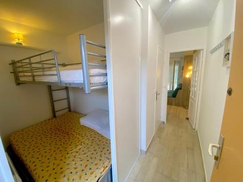 Cette petite chambre comprend 2 lits superposés et un couloir. dans l'établissement Studio avec piscine et jardin, à Sanary-sur-Mer