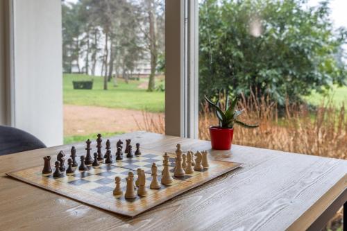 a chessboard on a table in front of a window at Brit Hotel Le Parc Vichy in Bellerive-sur-Allier