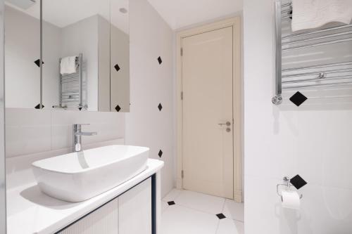 a white bathroom with a sink and a shower at Luxury Apartments in Ofton Residence in Istanbul
