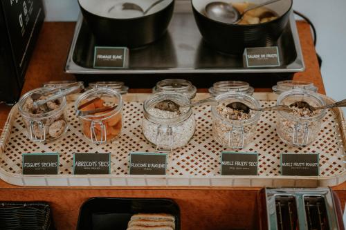 a tray with glass jars on a table at Brit Hotel Le Parc Vichy in Bellerive-sur-Allier