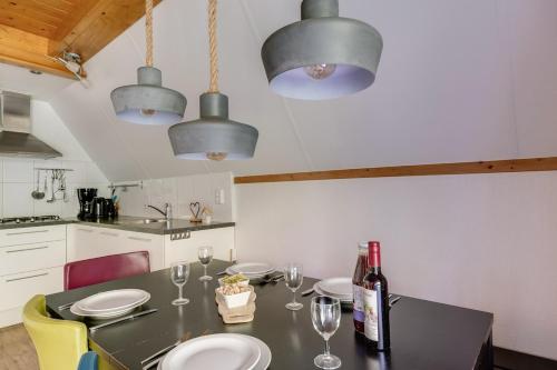 a kitchen with a table with glasses and a bottle of wine at Goudhaan I Fijne Accommodatie met Openhaard in Zwiggelte