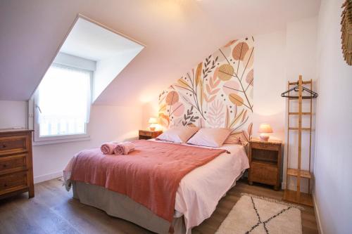 ein Schlafzimmer mit einem Bett mit einer orangefarbenen Tagesdecke in der Unterkunft Manava Villa vue mer et Mont Saint Michel piscine intérieure in Saint-Jean-le-Thomas