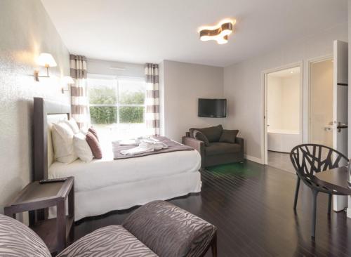 a hotel room with a bed and a couch at Au Pré Carré in Plumergat