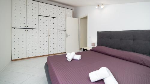 a bedroom with a purple bed with towels on it at La Mansarda di Via Montegrappa by Rentbeat in Civitavecchia