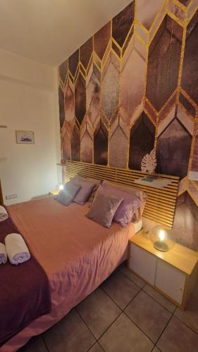 a bedroom with a large bed with a wooden headboard at CinqueStanze in Cosenza