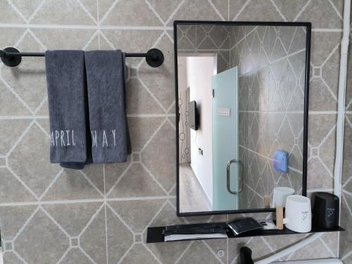 a bathroom with a mirror and towels on a counter at Prajna Pavilion in Dali Ancient Town