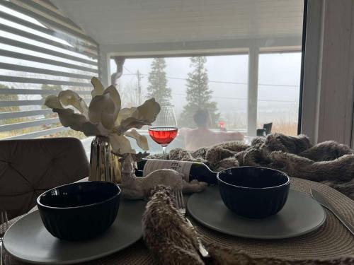 a table with two bowls and a glass of wine at Szarvas Vendégház in Zebegény