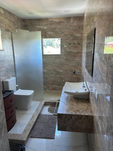 a bathroom with a sink and a toilet at Casa Itacimirim in Camacari