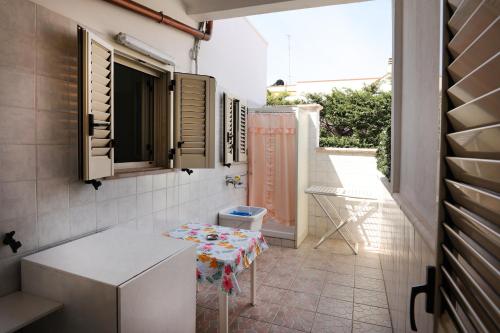 a small bathroom with a table and a window at A due passi dal mare by Salento Prime in Torre Vado