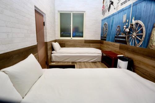 a room with two beds and a wall with a painting at 清境77窩House-包棟包層民宿 in Ren'ai