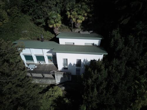an aerial view of a white house with a green roof at Guesthouse Monte Verità in Ascona