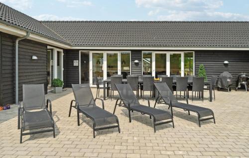 a patio with a table and chairs in front of a building at Gorgeous Home In Grenaa With Sauna in Grenå