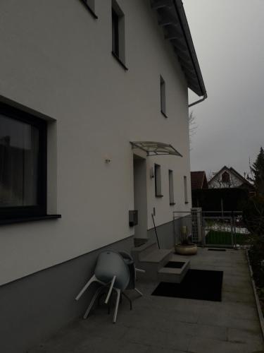 a white building with a chair and an umbrella at APARTMENT Top1, 2 Schlafzimmer 3 Betten BESTROOMS eU in Steyr