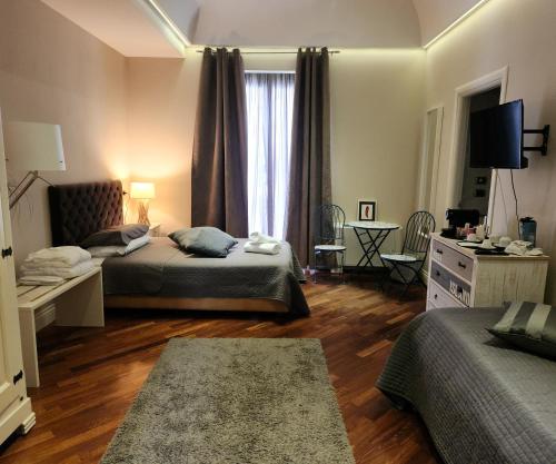a bedroom with two beds and a desk and a television at Le Sale Resort in Caserta