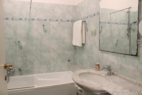 a bathroom with a sink and a tub and a mirror at Hotel Belle Epoque in Sanremo