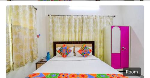 1 dormitorio con cama y puerta rosa en saltlake inn, en kolkata