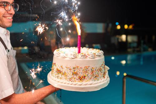 a man holding a birthday cake with a candle at Holiday Inn & Suites - Cairo Maadi by IHG in Cairo