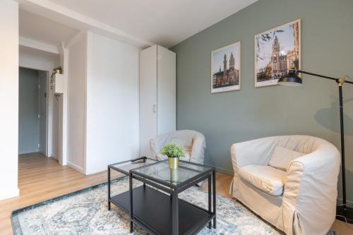 - un salon avec deux chaises et une table en verre dans l'établissement Lille Hypercentre - Gares - Charmant duplex, à Lille