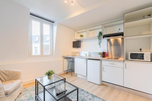 une cuisine et un salon avec un canapé et une table dans l'établissement Lille Hypercentre - Gares - Charmant duplex, à Lille