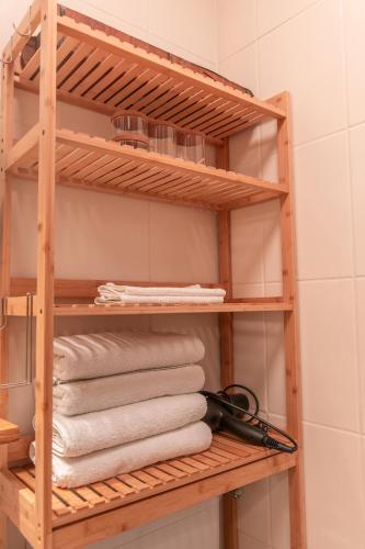 a wooden shelf in a bathroom with towels at Sam and Karo City Studio in Trier