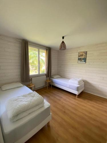 a bedroom with two beds and a window at Résidence de Nodeven in Guissény