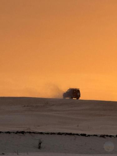 a jeep driving in the snow at sunset at Camp Dunes Insolites Sabria in Sabria