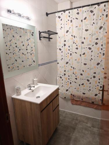 a bathroom with a sink and a shower curtain at Apartamento FIBES II edificio LUX SEVILLA in Seville